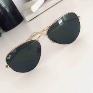  - Sparsamt använda Rayban-solglasögon i modellen ”Aviator”. Mäter 58 mm över glasen. 