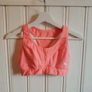  - Supersnygg korall sporttop från Ginatricot! I väldigt bra skick som går att justeras i ryggen. 40kr+frakt