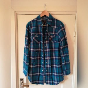  - Fin lite längre rutig flanellskjorta. Knappt använd.