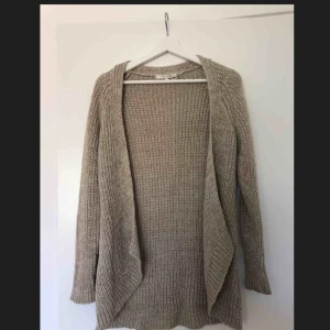  - Längre beige kofta från Easy Wear, vet inte varför det står storlek 42 för det är definitivt en XS/S. Har en liten fläck på ena ärmen men syns knappt pga mönstret. Kan mötas i Stockholm eller så betalar köparen frakt!