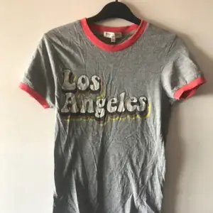 Retro ”Los Angeles” t-shirt i grått med fina färgdetaljer i kragen och på trycket. I XS men sitter bra på mig som oftast är S. Gott skick. Pris kan diskuteras, tar Swish!