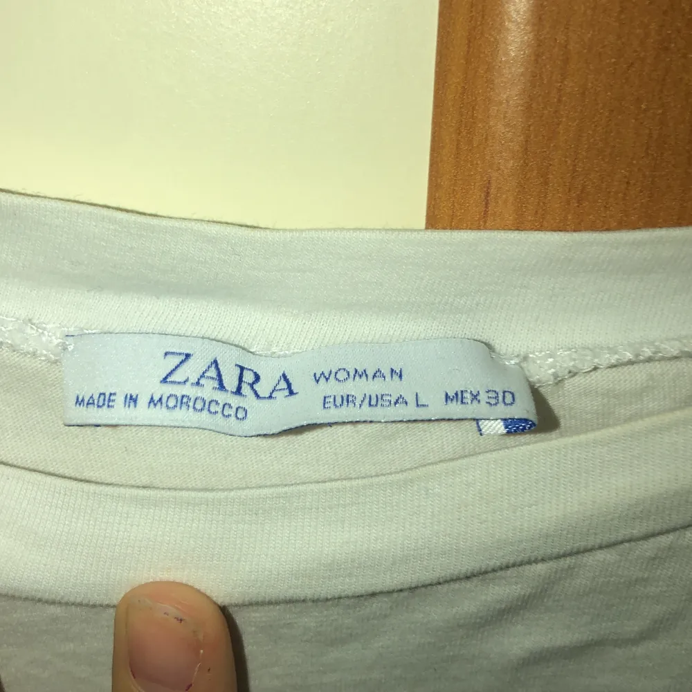 En vit t-shirt från Zara med tryck på. Trycket är en nyckelknippa. Köpt i Storlek L för att få en oversized look. . T-shirts.
