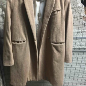  - Kamelfärgad kappa från H&M. I använt skick.