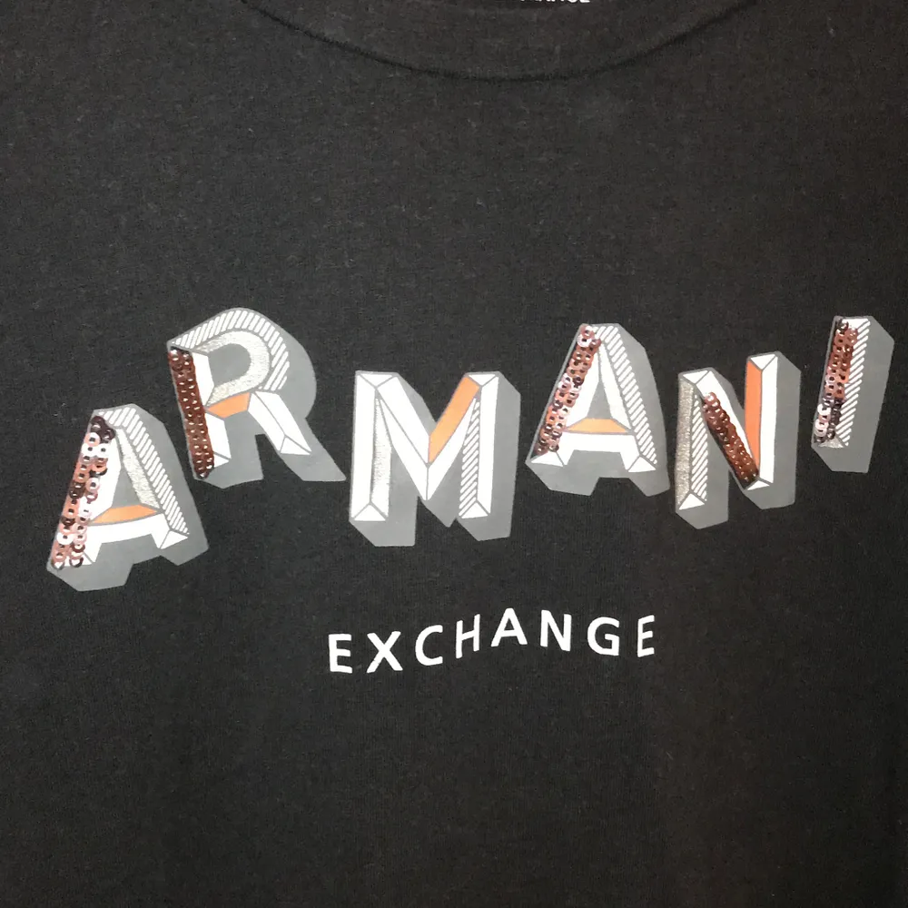 Svart långärmad tröja från Armani! Texten är delvis med paljetter också💃🏻 tröjan är i storlek M, tröjan är använd några gånger men i bra skick!! . T-shirts.