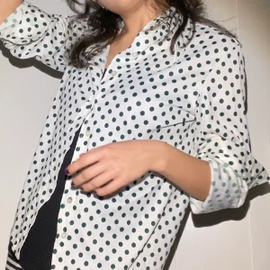 vintage skjorta - Vit skjorta med gröna prickar i jättebra skick! Storlek står inte men gissar att den är i XS/S, som jämförelse har jag själv XS (se bild). Pris går att disskutera, frakt går att få spårbar.