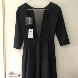 Ny svart klänning från NLY i stl 34/36 - Svart oanvänd klänning i skatermodell med djup urringning från NLY. Storlek ca 34/36. Aldrig tvättad, lappar kvar.   Rökfritt/djurfritt hem. Tvättar parfymfritt 