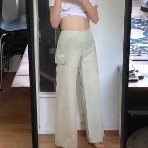 Vida byxor i coolt material - Skiiitsnygga, vida byxor i coolt material! Nästan lite regn-jacka-material kan man säga! Ficka hänger löst som man kan se på sista bilden! Dragkedja i sidan