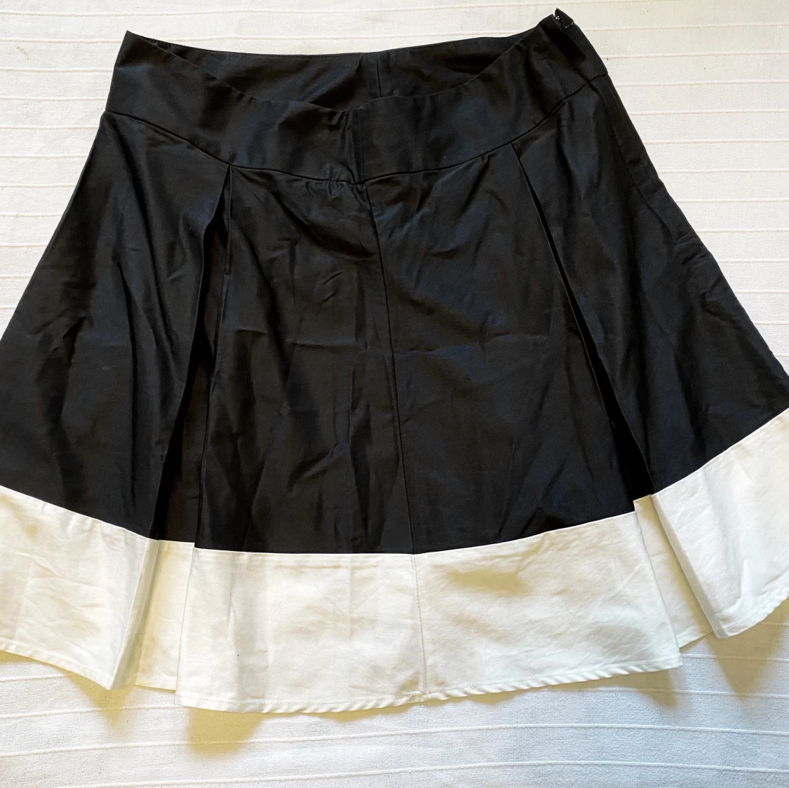 Fin veckad kjol i svart och krämvit