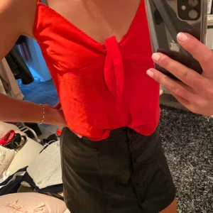 Röd knyt topp - Super fin röd topp med ett knyte vid bröstet