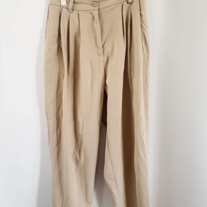 Chinos från Weekday - Beiga snygga chinos från Weekday. Baggy passform  och i bra skick. Inköpspris 500kr. Säljer pga lite för små i midjan för mig som vanligtvis har storlek 38. Pris kan diskuteras💕