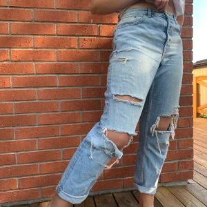 Ljusa jeans med hål storlek. 31 - Boyfriend jeans från H&M, nåt år gamla men fortfarande fina. Trådarna över hålen har gått av annars inte mycket tecken på användning. Du står för frakten:)