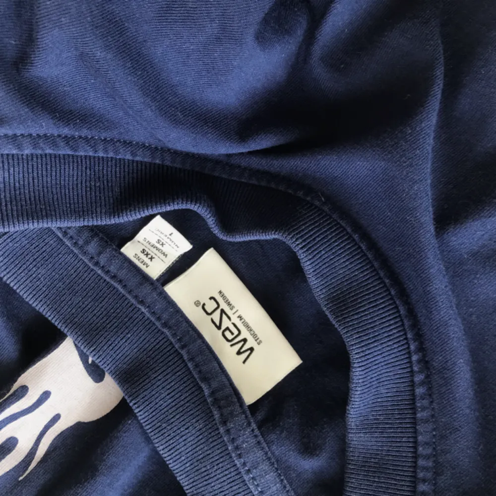 Mörkblå långärmad tröja med text på ärmarna från WEZC, använd fåtal gånger, riktigt fint skick! Köptes för ca 500kr. Toppar.