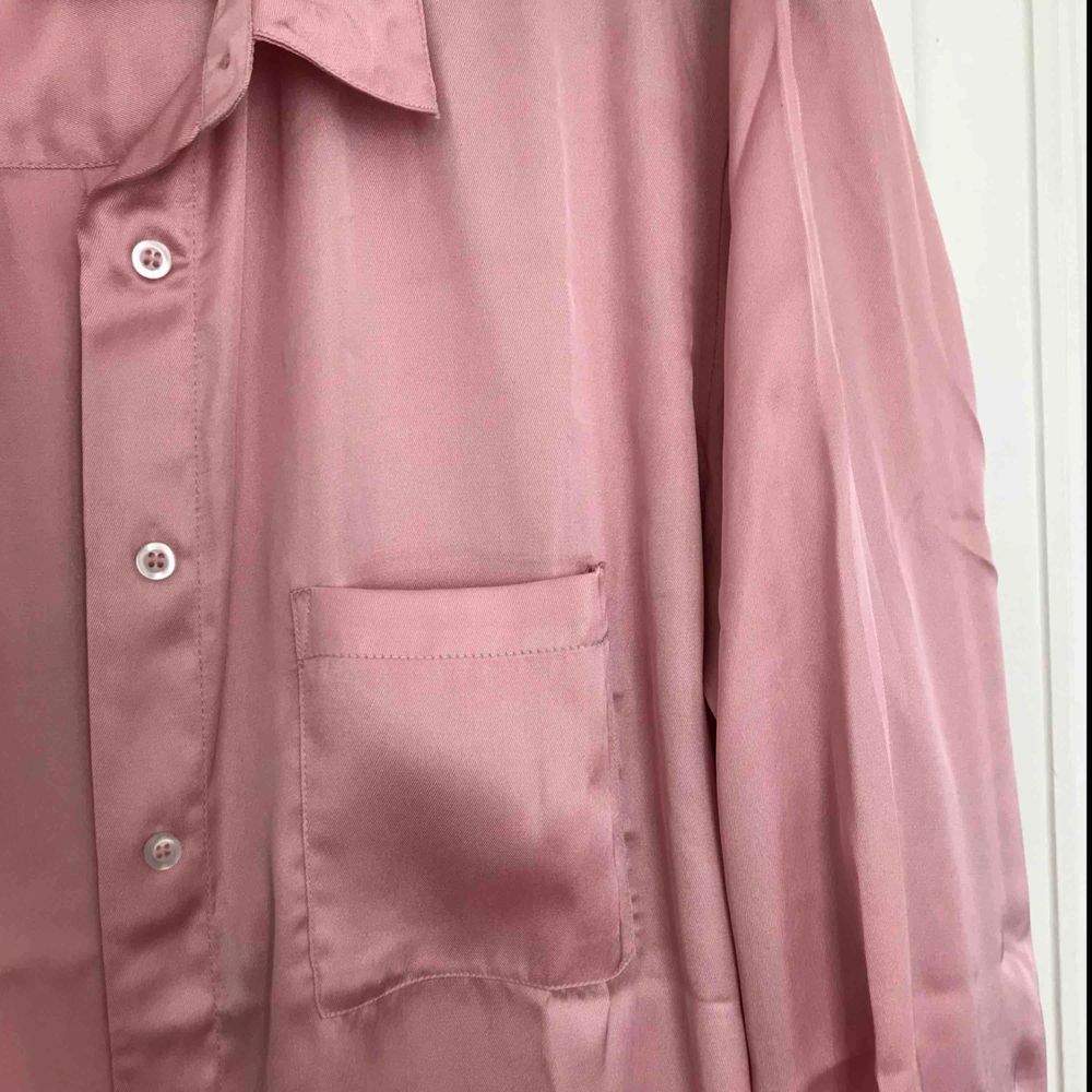 Helt NY blus i fint glansigt material!  Aldrig använd. Perfekt till sommaren, jättefint rosa färg. . Skjortor.