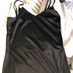  - En svart glansig klänning o ganska kort + frakt