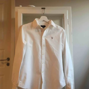  - Vit Ralph Lauren skjorta, dammodell. Fint skick. Kan mötas upp i Stockholm eller frakta (köparen betalar).  