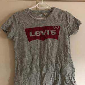 Grå Levi’s tshirt i bra skick, knappt använd och säljer pga använder ej längre! Vill ni ha bild hur den ser ut på så skriv i chatten så löser jag det!🤍 Tvättar/stryker den innan + köparen står för frakten som ligger på cirka 63kr💖