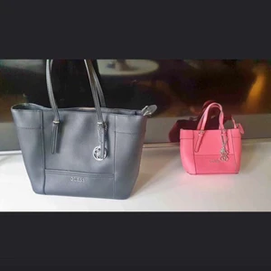 Guess väskor - Säljer 2 st guess väskor, Den rosa är oanvänd men tyvärr så saknas axelbandet. Den svarta är i bra skick men finns en liten sprucken söm, kan skicka bild vid intresse. 1 000 för båda eller 700 för den rosa och 400 för den svarta + frakt