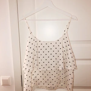 Vitt linne med 🖤 hjärtan  - Supergulligt vitt linne som i princip bara legat i garderoben då det inte är min stil och kan komma till bättre användning av någon annan! 50kr eller bud! 🦋💕