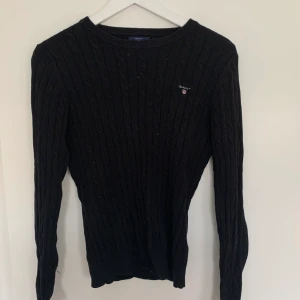 Svart kabelstickad GANT tröja  - Säljer denna kabelstickade GANT tröja. Knappt använd & väldigt fint skick ! Storlek S men passar även mig med M då den är väldigt stretchiga. Ny pris 1299, mitt pris 500. Billigare vid snabb affär.