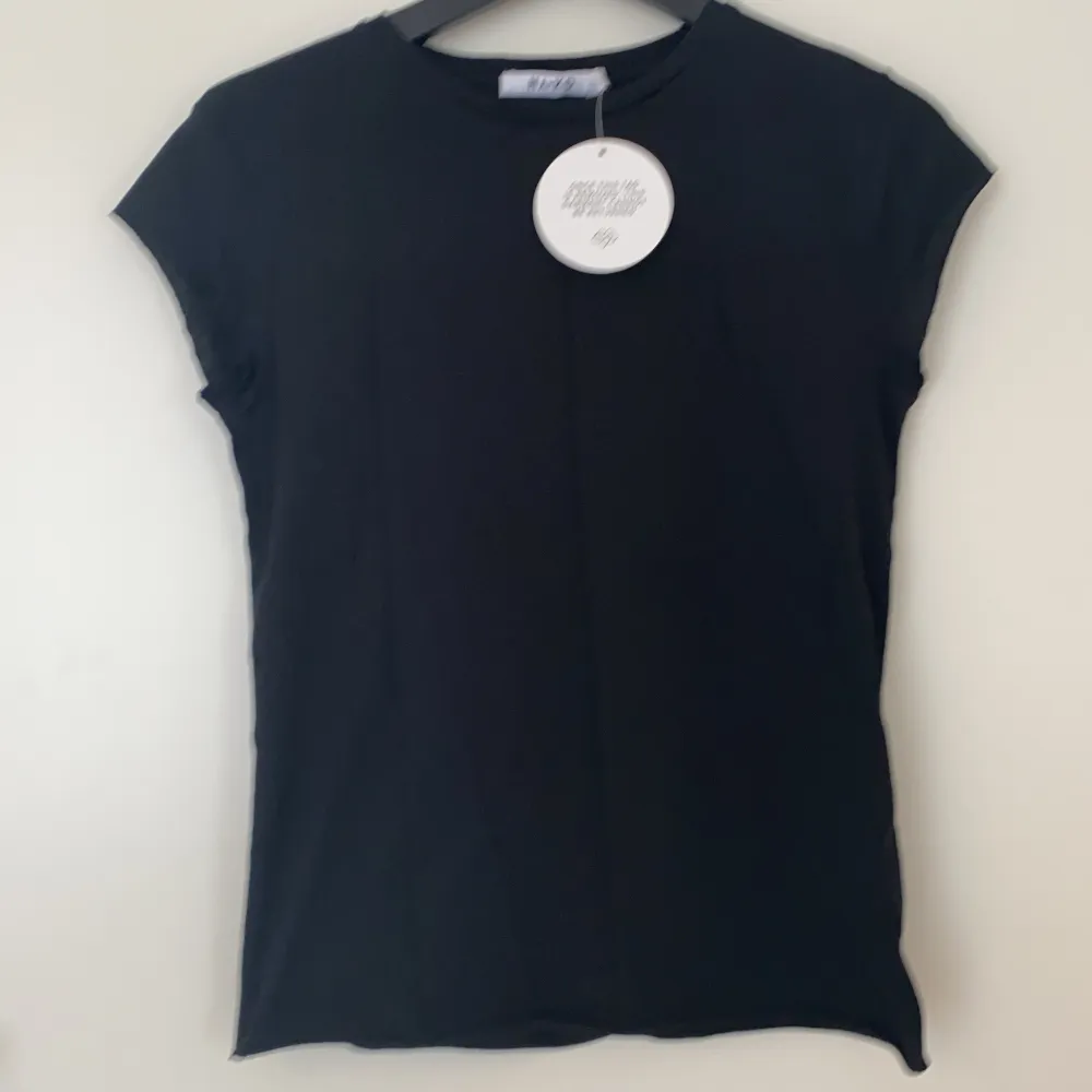 En svart T-shirt från NAKD med tyck på baksidan. Aldrig använt, prislappen är på. I storlek XXS men den är som en XS. Fraktkostnad tillkommer. . T-shirts.