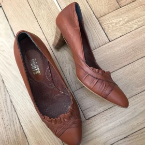 Klackskor - Skor, klackskor, pumps i rödbrunt skinn! Använda några gånger men tyvärr för små för mig, så finfint skick utöver normalt slitage under sulan. Snygga till vår & sommar! Roots, storlek 36. Klack 5cm från häl nedåt. Kan mötas i Stockholm eller skicka mot fraktkostnad! ✨ 🌸✨ 