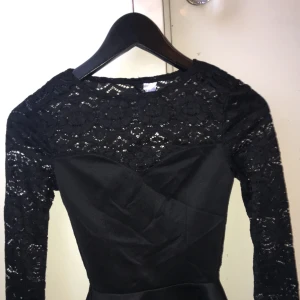  - !!BUDA!! Svart spets peplum topp. Köpt på H&M  Endast använd en gång. Baksidan av tröjan är see through, se bild 2.  Storlek: XS