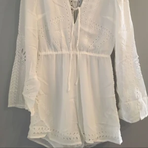  - Jumpsuit med spets. Underdelen är fodrad. Dragkedja bak. 