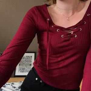 Vinröd ”lace-up” tröja från HM. Aldrig använd. Säljs då den är för kort i armarna för mig.