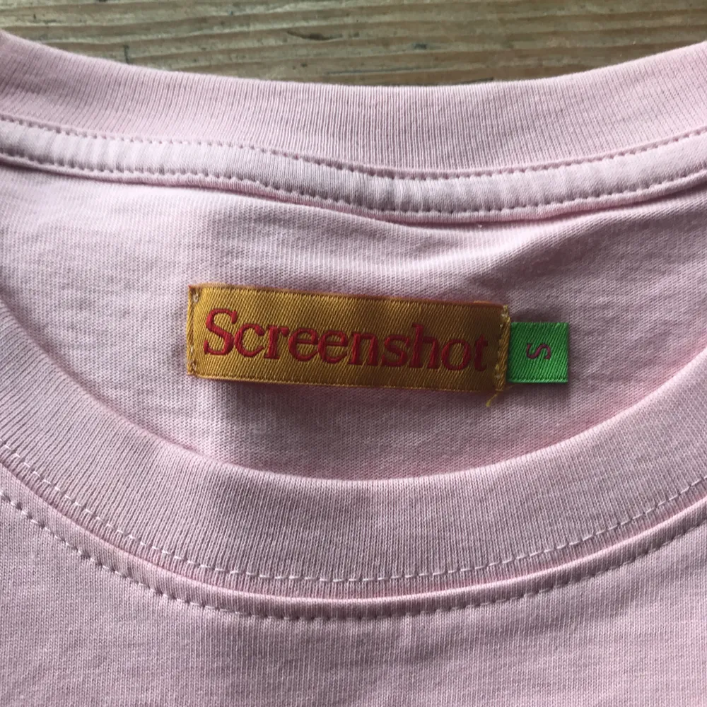 pastellrosa t-shirt från Screenshot, står S men känns mer som M. Aldrig använd. köparen står för frakt. . T-shirts.