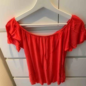  - Söt topp i lite mörkare korall färg, ser orange ut på bilden men tycker den är mer korall. i storlek 40. Denna är använd en enda gång. Finns även en vit som jag säljer i samma storlek. Går att använda både som off shoulder och på axlarna. 