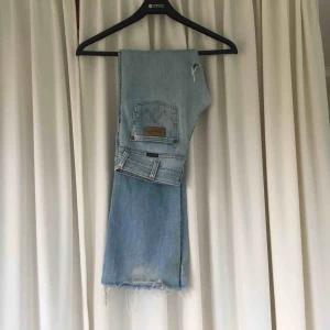  - Äkta 90-talsjeans från Wrangler. Lågmidjade och utsvängda i benen. Skiiitsnygga!! Slitna vid låret vilket enligt mig är en ball detalj. De är långa på mig som är 160 cm. Köparen står för frakt! 