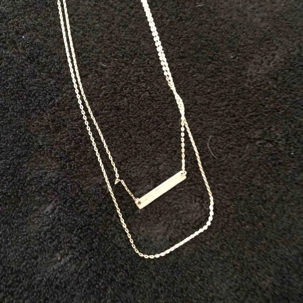Ett silvrigt halsband från Bikbok.. Accessoarer.