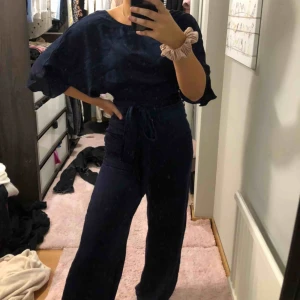  - Byxdress i ”silke” material från NLY, aldrig använd o lappar kvar. Den är lite öppen i ryggen och har vida armar, mörkmörkblå. Fraktar för 66kr