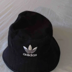  - Adidashatt med en liten brun fläck på märket efter att jag klättrade i grottor med den. Köparen står för frakten 