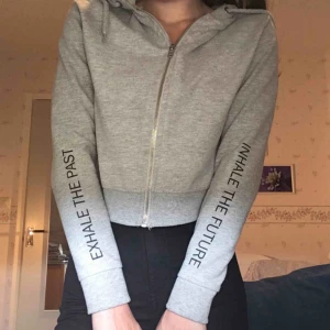  - Grå croppad huvtröja med svart text på ärmarna!