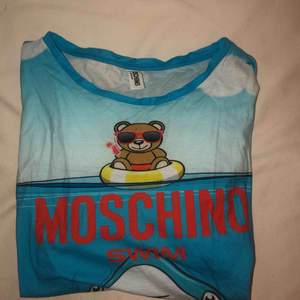 Supercool äkta Moschino-swim T-shirt. Inköpt i Italien för ca ett halv år sedan. Säljes pågrund av för stor! ANVÄND 0 GÅNGER