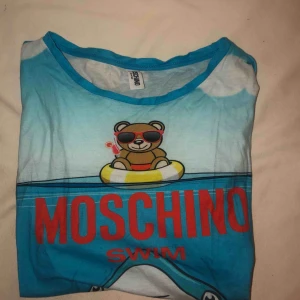  - Supercool äkta Moschino-swim T-shirt. Inköpt i Italien för ca ett halv år sedan. Säljes pågrund av för stor! ANVÄND 0 GÅNGER