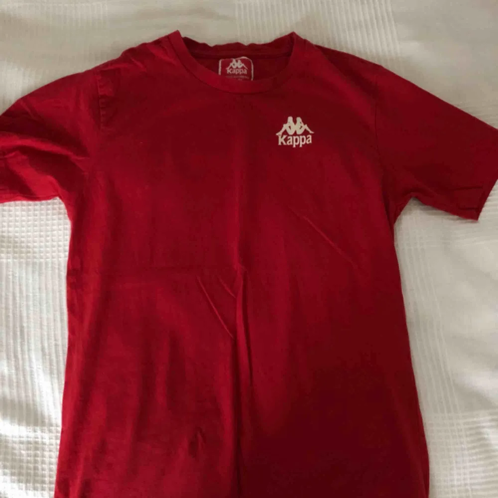 En röd Kappa t-shirt med print där fram och där bak.. T-shirts.