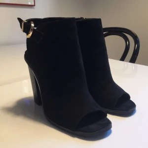  - Svart mocka-imitation med gulddetalj baktill från Primark London. Superfint skick! Använda endast 2 gånger pga för liten storlek, så sulan/klacken är nästan helt nyskick! 