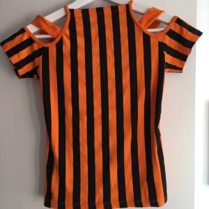  - Annorlunda och cool orangerandig coldshoulder-topp som jag köpt i Berlin. Den är i fint skick och väldigt bekväm att ha på sig, snygg till en fin sommarbränna!