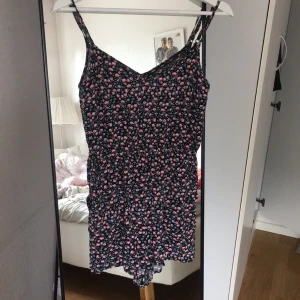  - Byxdress med fin detalj i ryggen, justerbara axelband och fickor