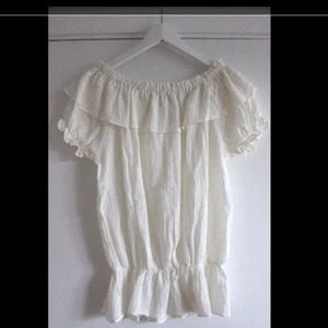  - Snygg vit blus med volanger och fina detaljer från Lise Sandahl. Helt oanvänd! Säljer även en likadan i svart. 