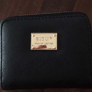  - Helt oanvänd plånbok i fuskskinn. Flera fack för kort och ett vit-/rosaprickigt fack för mynt.  