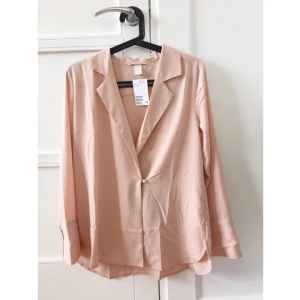  - Urringad puderrosa blus i oversize-modell.