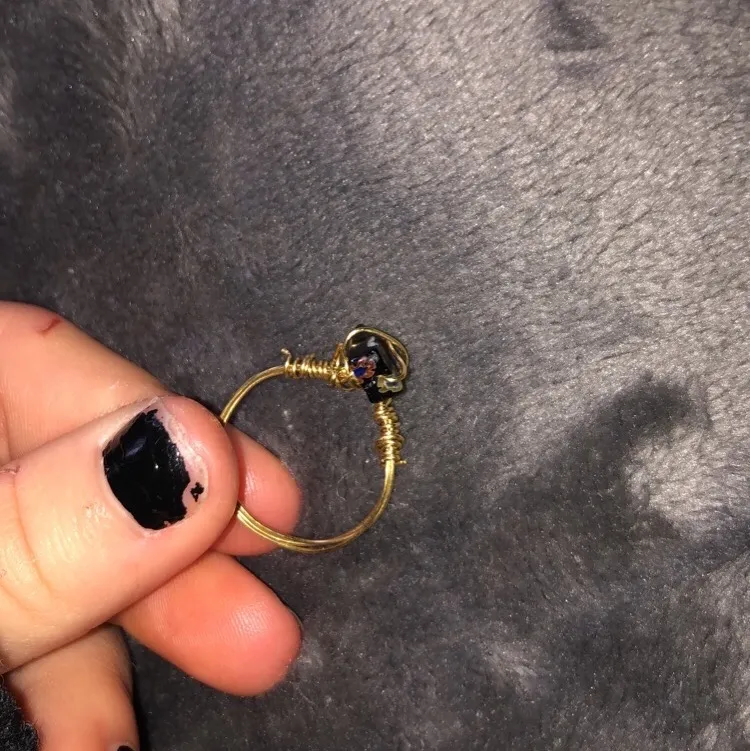 Säljer lite ringar som jag gjort själv, ringen är gjord av guldig ståltråd och en svart pärla/Sten med små blommor på. Säljer denna ring för 15 kr+ 11 kr i frakt. DMa mig vid intresse!. Accessoarer.
