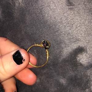 Säljer lite ringar som jag gjort själv, ringen är gjord av guldig ståltråd och en svart pärla/Sten med små blommor på. Säljer denna ring för 15 kr+ 11 kr i frakt. DMa mig vid intresse!