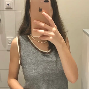 Grå Stickad Väst - Jättefin grå sweater vest med vita och bruna detaljer🤩 Uppsydd där nere (kan skicka bilder). Storlek M men passar mindre (jag har vanligtvis xs), väldigt stretchig🥰 Frakt 22kr💗