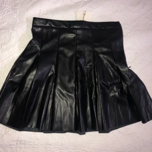 Plisserad kort kjol i läder - Kjol från Pull & Bear, prislapp kvar, säljer pga att den ej passar mig, den är slutsåld överallt vad jag har sett!