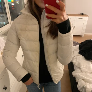 Vit dunjacka  - Vit dunjacka. Står inget märke på plagget. Knappt använd.