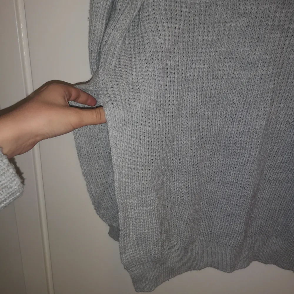 En grå stickad tröja från Pretty Littel Thing med en slit på båda sidor. Väldigt mysig och den är i bra skick. . Stickat.